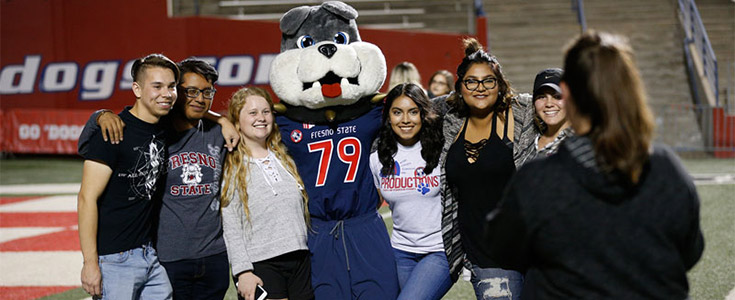 Fresno State students taking a group photo with mascot Time-Out